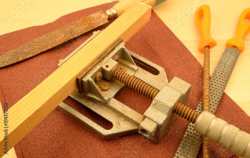 Lavoro manuale, attrezzi per falegnameria: morsa, raspe di vario tipo e carta vetrata photo