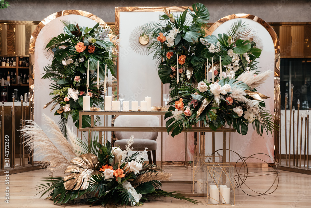 Wedding luxury decor. Wedding presidium for the newlyweds. Beautiful decor with pastel roses, candles and greenery. Indoors Wedding luxury decor. Wedding presidium for the newlyweds. Beautiful decor with pastel roses, candles and greenery. Indoors