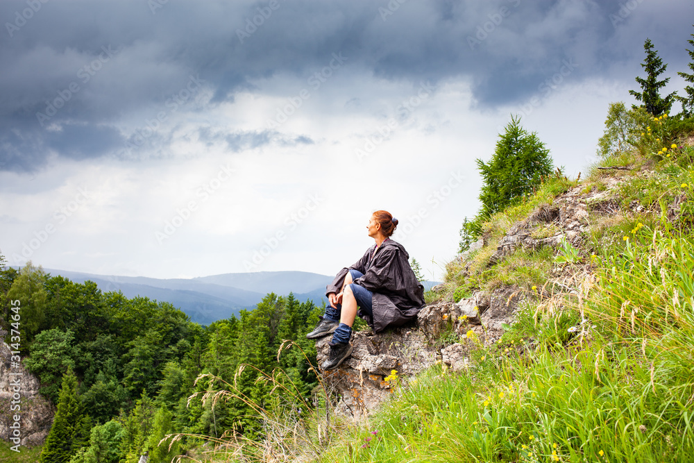 Fototapeta premium woman hiker with raincoat looking at beautiful spring landscape