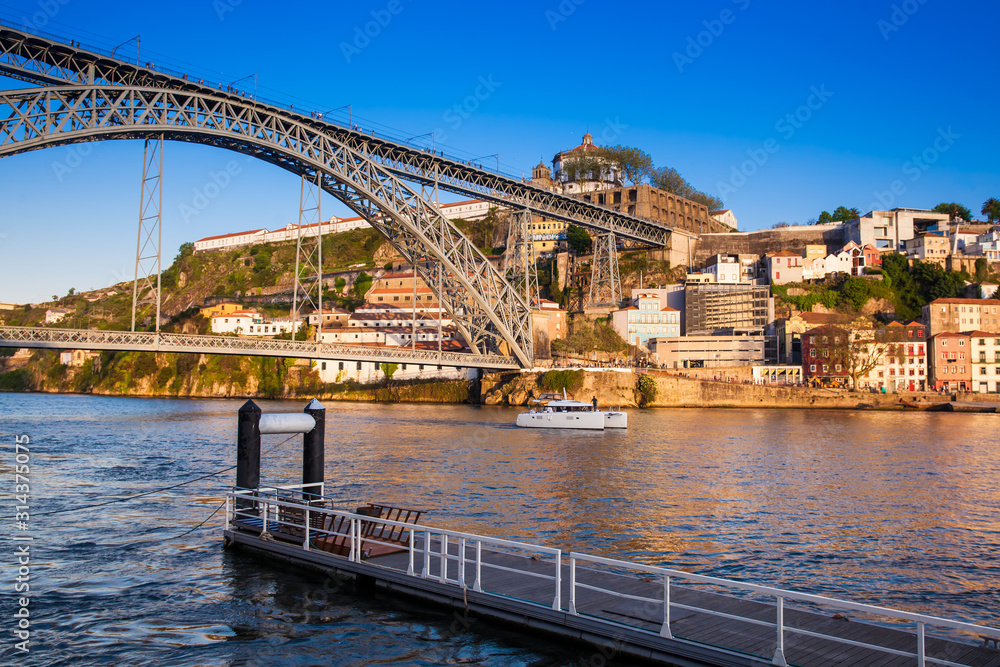 Modern boat and the Dom Luis I Bridge a metal arch bridge over the Douro River between the cities of Porto and Vila Nova de Gaia in Portugal inaugurated in 1886