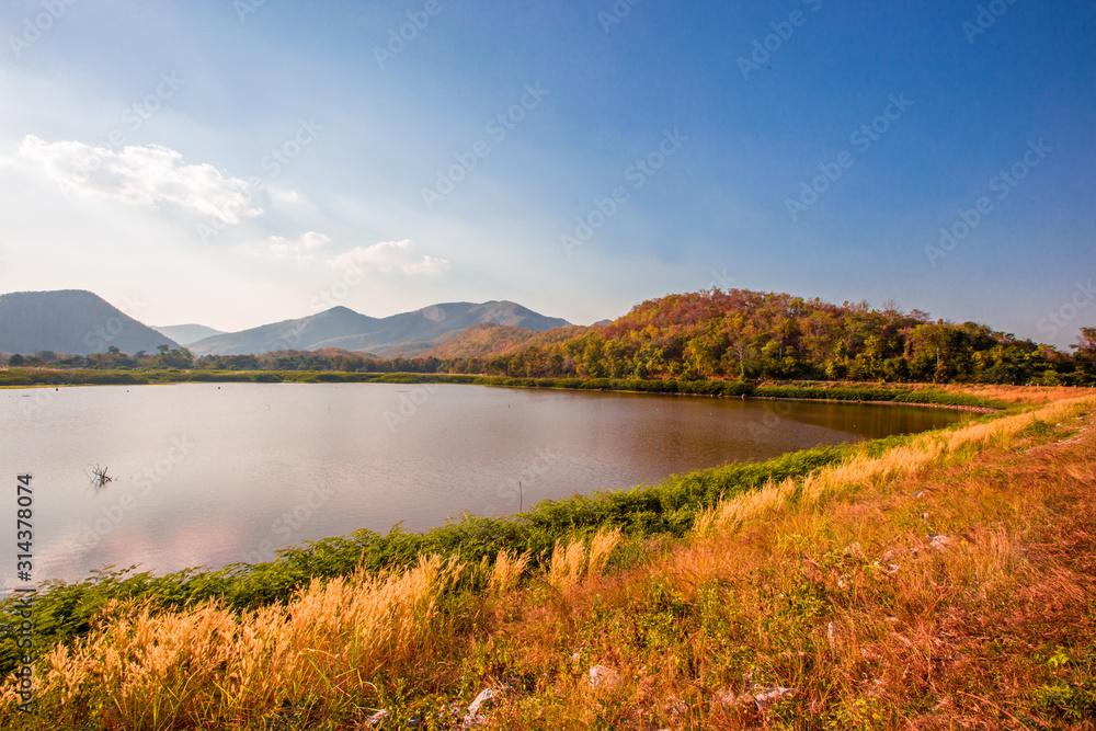 The blurred panoramic nature background of sunlight hitting the lake's surface, grass and wind blowing all the time along the large mountains, ecological beauty and fresh air. The blurred panoramic nature background of sunlight hitting the lake's surface, grass and wind blowing all the time along the large mountains, ecological beauty and fresh air.