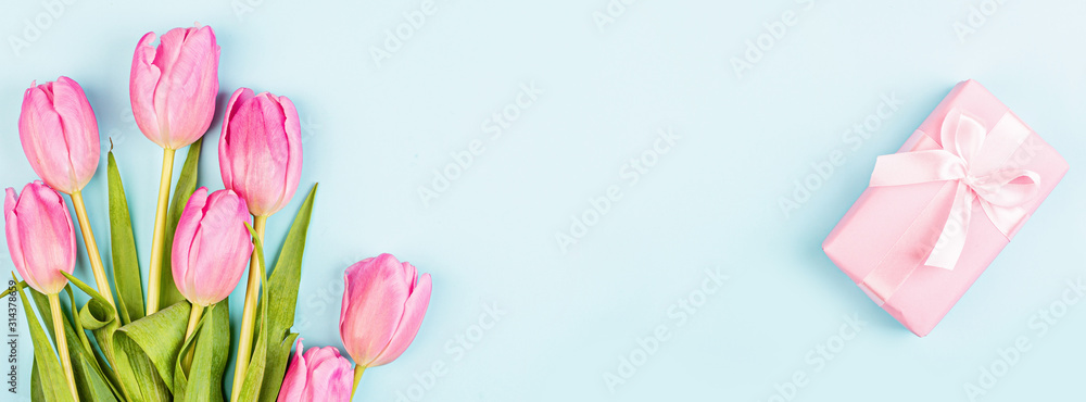 View from above tulips and gift box with copy space on blue. Background for womens day, 8 March Valentines day, 14 february. Flat lay style, top view, mockup, template, overhead. Greeting card
