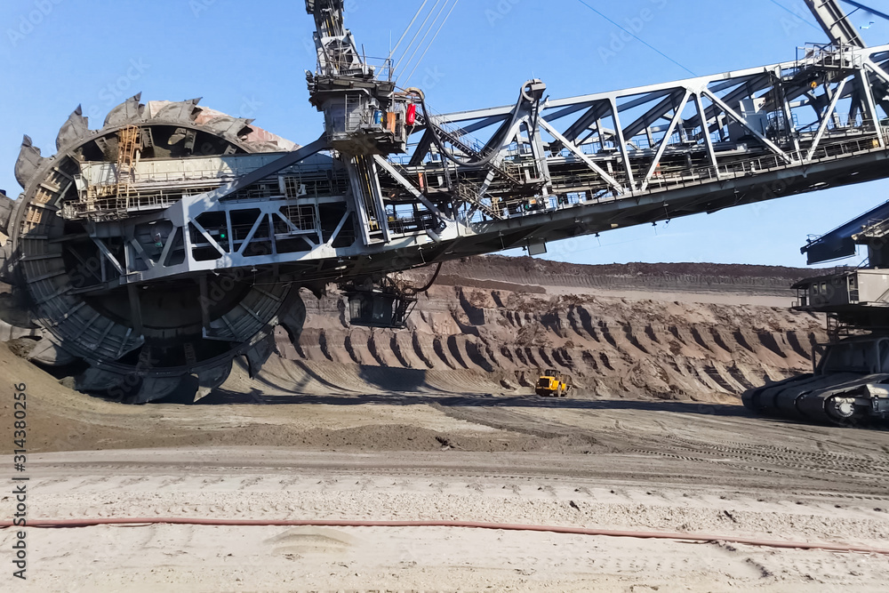 Fototapeta premium work of a bucket wheel excavator in a quarry. Ore mining in a quarry.