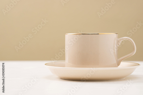 A cup of coffee is placed in front of a warm background.