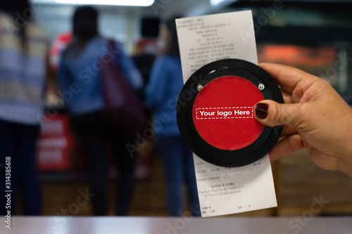 Hand showing Invoice with Wireless calling system restaurant or pager customers system  and person row background.