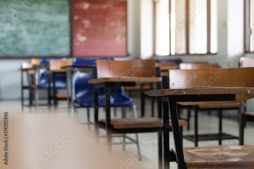 selective soft and blur focus.old wooden row lecture chairs in dirty classroom in poor school.study room without student.concept for education in third world ,donate and charity,background text.