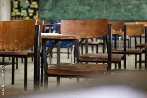 selective soft and blur focus.old wooden row lecture chairs in dirty classroom in poor school.study room without student.concept for education in third world ,donate and charity,background text.