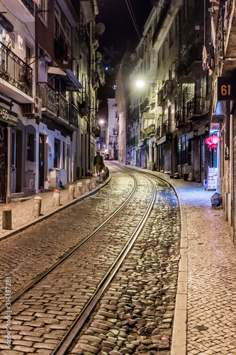 LISBON, PORTUGAL - OCTOBER 9, 2017: Night view of tram tracks at Cavaleiros street in Lisbon, Portugal