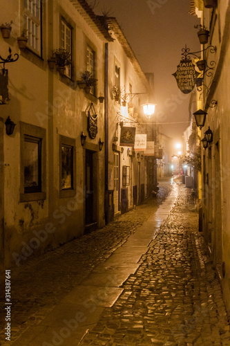 OBIDOS, PORTUGAL - OCTOBER 11, 2017: Night view of a narrow cobbled street in Obidos village, Portugal