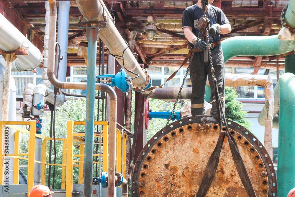 Male workers assemblers mount a shell-and-tube heat exchanger, repair ...