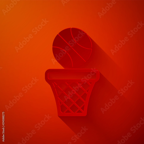 Paper cut Basketball ball and basket icon isolated on red background. Ball in basketball hoop. Paper art style. Vector Illustration