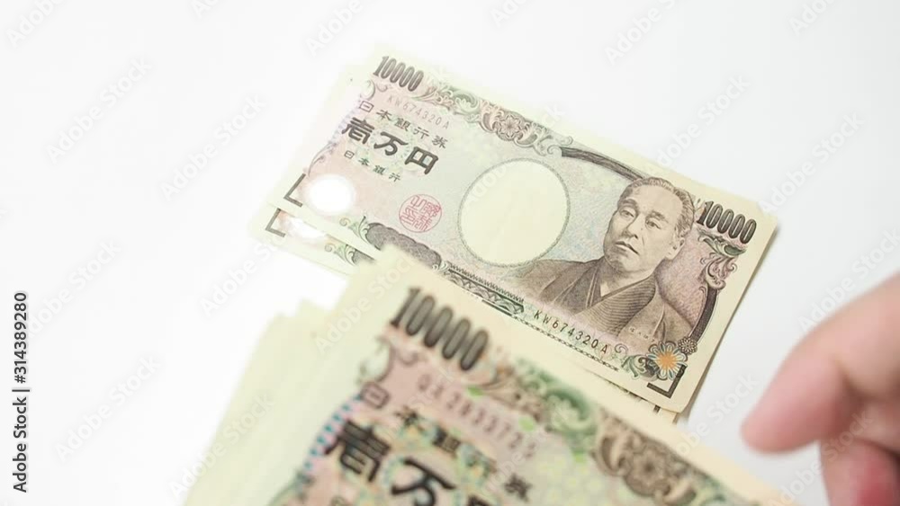 Hand counted Japanese Banknote money on white table. Concept for japan economic and financial business. Hand counted Japanese Banknote money on white table. Concept for japan economic and financial business.