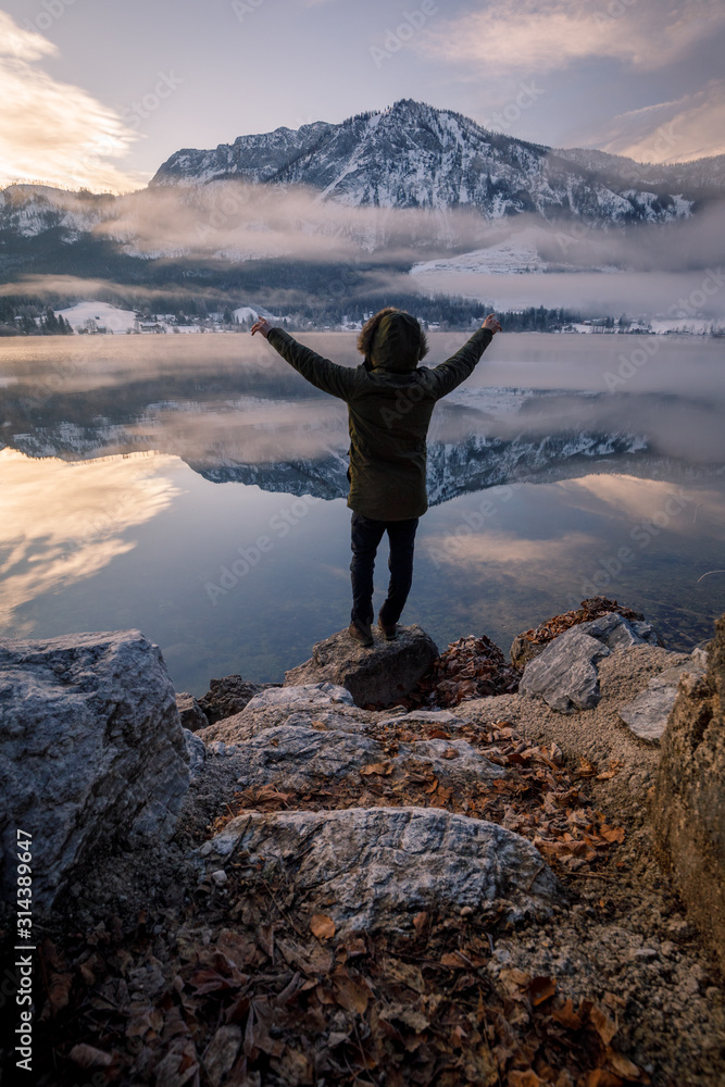 man enjoys the perfect nature view of the winter lake and mountains. man enjoys the perfect nature view of the winter lake and mountains.