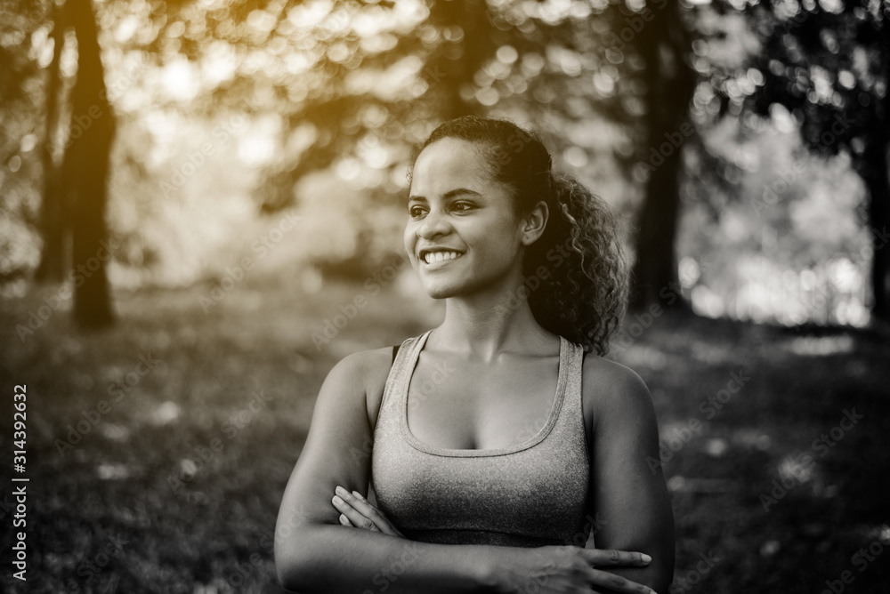 Attractive black woman smiles emotionally posing after break workout at outdoor,Positive thinking and smiling,Relax time,Black and white toned Attractive black woman smiles emotionally posing after break workout at outdoor,Positive thinking and smiling,Relax time,Black and white toned