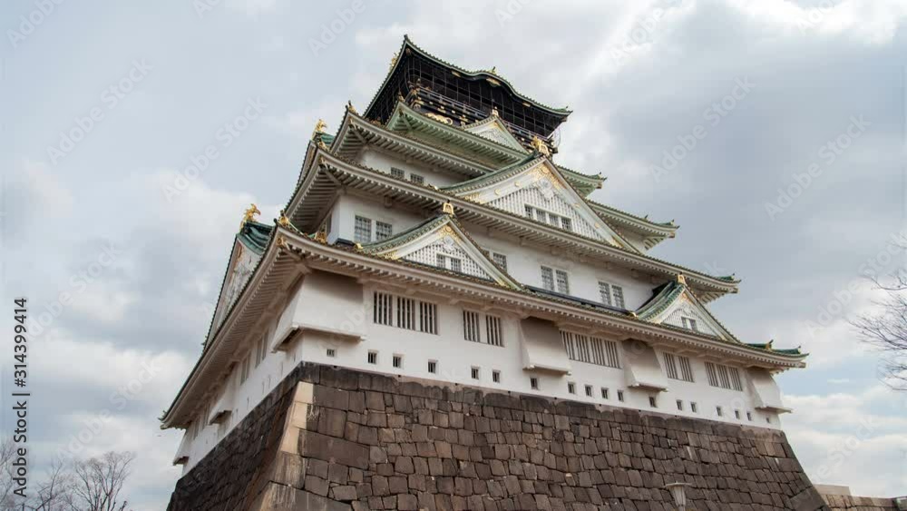 Timelapse Osaka samurai castle golden palace landmark and museum with fortification wall under cloudy sky close low angle shot Timelapse Osaka samurai castle golden palace landmark and museum with fortification wall under cloudy sky close low angle shot