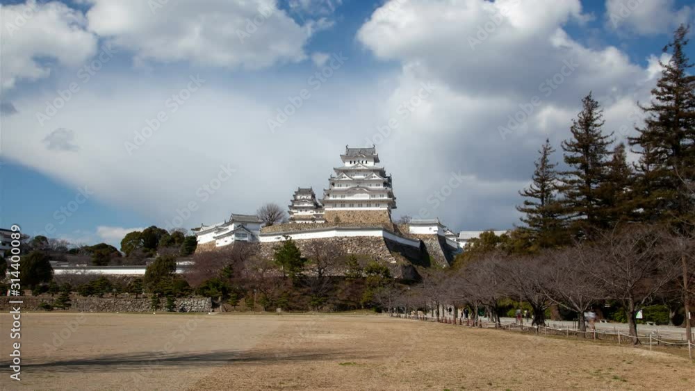 Timelapse Himeji castle of orient historical landmark with palace complex on hill under blue sky with white clouds on sunny day Timelapse Himeji castle of orient historical landmark with palace complex on hill under blue sky with white clouds on sunny day