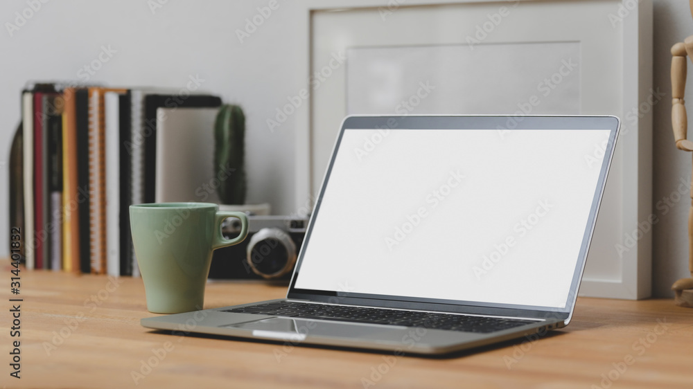 Close up view of comfortable workspace with mock-up laptop and office supplies on wooden desk Close up view of comfortable workspace with mock-up laptop and office supplies on wooden desk