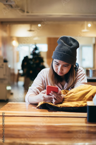Beautiful Asian girl using smart phone in cafe
