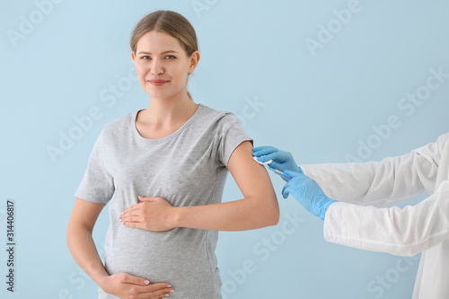 Doctor vaccinating pregnant...
