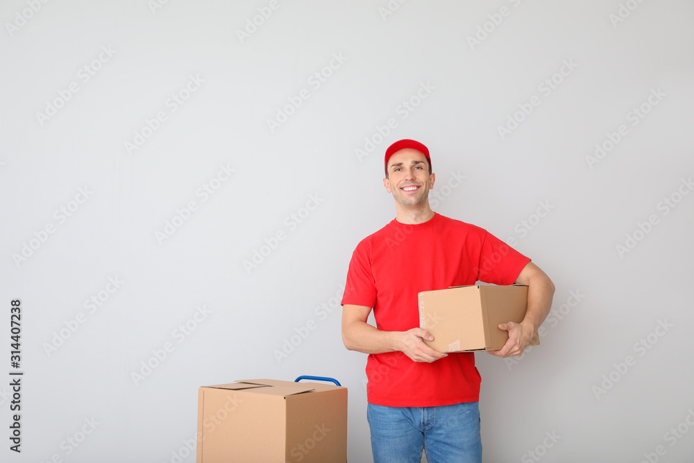 Delivery man with boxes on light background Delivery man with boxes on light background