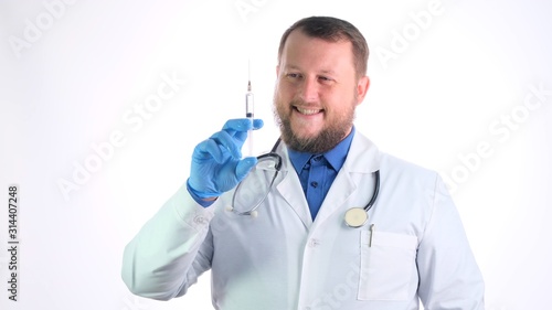 bearded male doctor in a white coat holds a syringe and a needle in his hands on a white isolated background. This is for you to get better