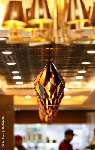 A reddish-brown lamp hanging from the ceiling in the building.