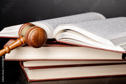 Wooden gavel and juridical books close up