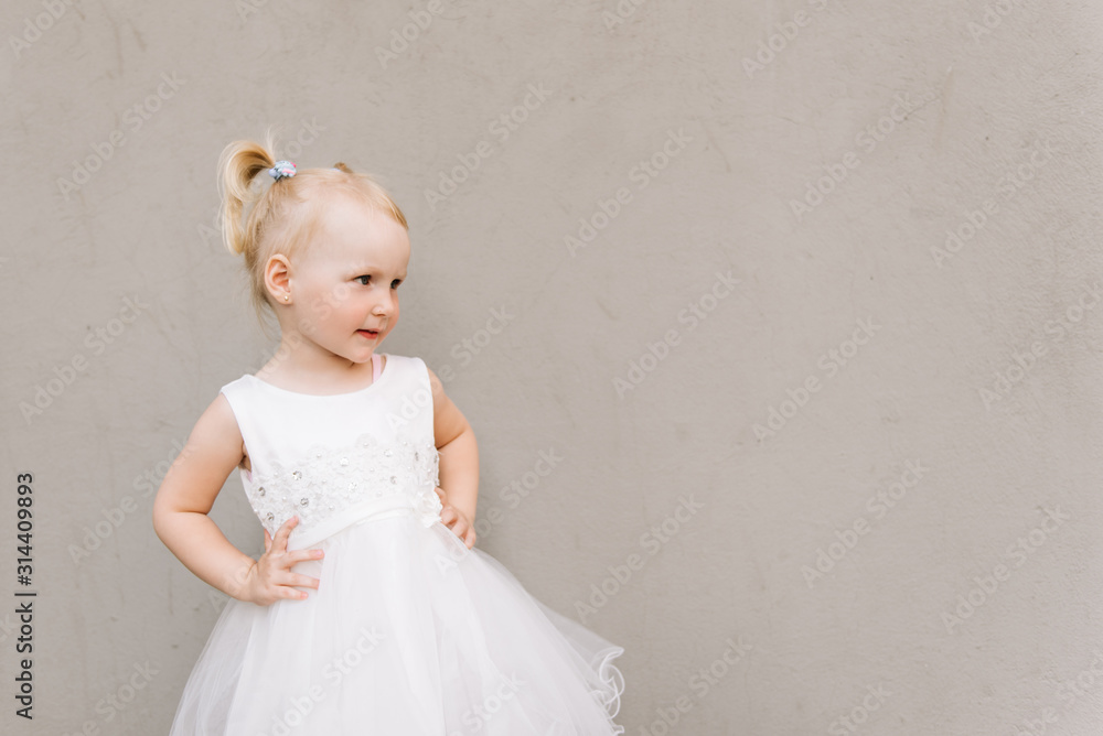 Happy baby girl in white dress on grey background Happy baby girl in white dress on grey background