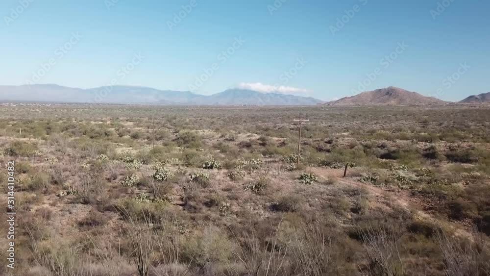 Low angle aerial view of Sonoran desert and a dirt trail in Arizona, USA with the Santa Rita Mountains in the distance Low angle aerial view of Sonoran desert and a dirt trail in Arizona, USA with the Santa Rita Mountains in the distance