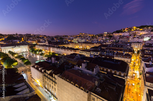 View of the Rossio Square (Praca do Rossio), historical Baixa and Alfama districts and Rua de Santa Justa street towards Castelo de Sao Jorge from above in Lisbon, Portugal, in the evening.
