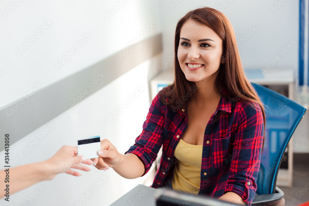 Smiling woman sitting in the office taking bank card and happy looking Smiling woman sitting in the office taking bank card and happy looking