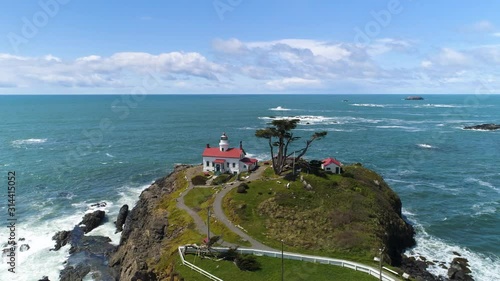 Aerial view of Pacific Ocean horizon with waves crashing into lighthouse. photo