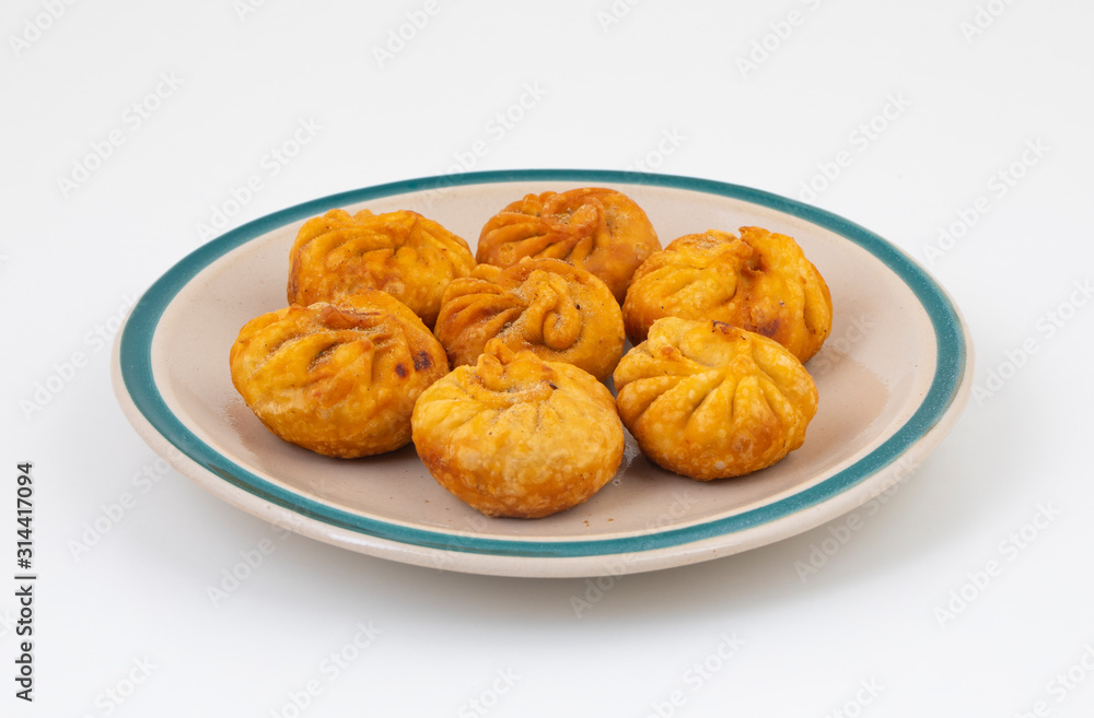 Fried Momos is a Traditional Dumpling Food From Nepal Served with Schezwan Sauce & Cream Fried Momos is a Traditional Dumpling Food From Nepal Served with Schezwan Sauce & Cream