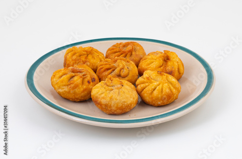 Fried Momos is a Traditional Dumpling Food From Nepal Served with Schezwan Sauce & Cream
