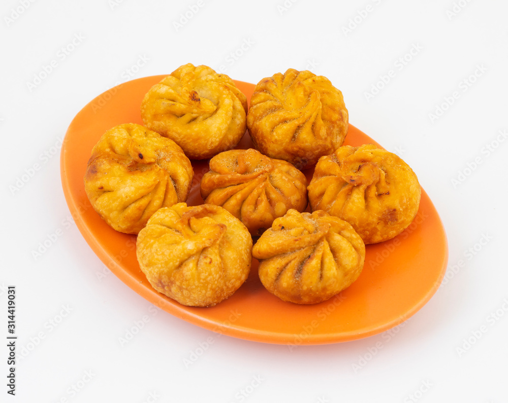 Fried Momos is a Traditional Dumpling Food From Nepal Served with Schezwan Sauce & Cream Fried Momos is a Traditional Dumpling Food From Nepal Served with Schezwan Sauce & Cream