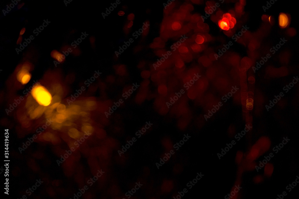 Obraz premium Yellow glitter lights on a black background. Bokeh of holiday lights on a black background. Background abstract yellow glitter lights. Gold abstract bokeh background on black. Defocus.