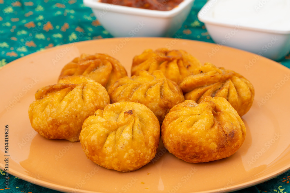Fried Momos is a Traditional Dumpling Food From Nepal Served with Schezwan Sauce & Cream Fried Momos is a Traditional Dumpling Food From Nepal Served with Schezwan Sauce & Cream