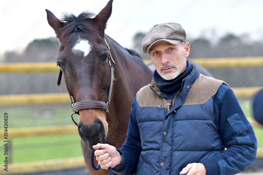 Obraz premium Portrait of horseman standing by horse