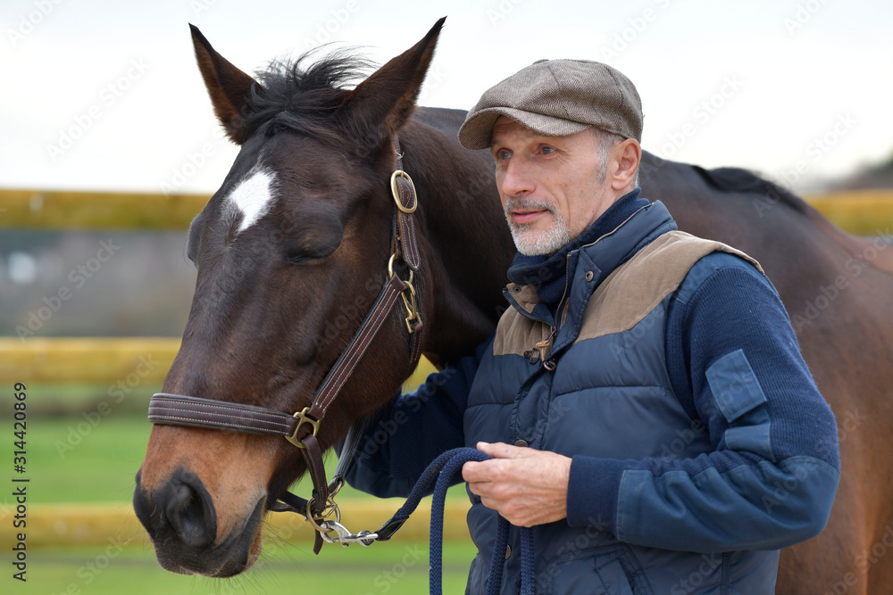 Obraz premium Portrait of horseman standing by horse