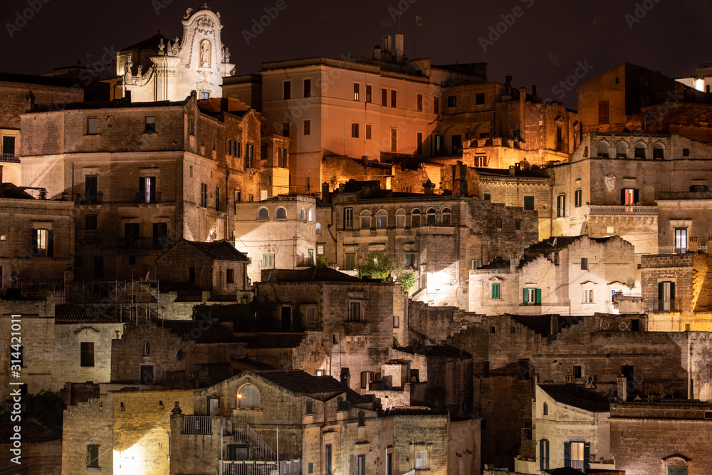 Amazing lighted buildings in ancient Sassi district by night in Matera, well-known for their ancient cave dwellings. Basilicata. Italy
