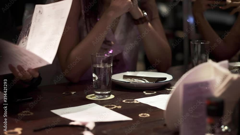 Pouring water in the glasses during friends dinner in restaurant. Concept of Greece, purity, healthcare, wellbeing, happy family, party with friends Pouring water in the glasses during friends dinner in restaurant. Concept of Greece, purity, healthcare, wellbeing, happy family, party with friends
