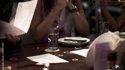Pouring water in the glasses during friends dinner in restaurant. Concept of Greece, purity, healthcare, wellbeing, happy family, party with friends