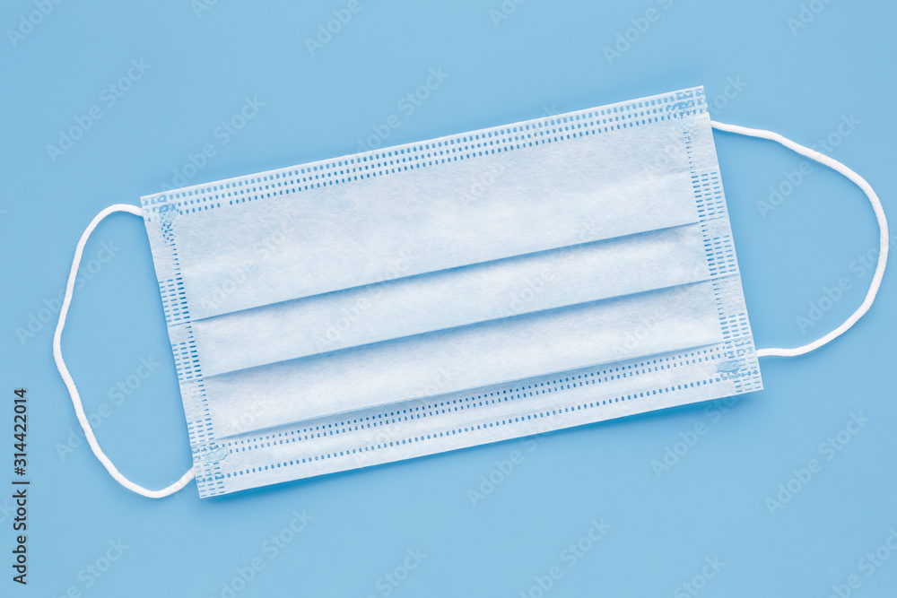 Surgical mask with rubber ear straps. Typical 3-ply surgical mask to cover the mouth and nose. Procedure mask from bacteria. Protection concept. Surgical mask with rubber ear straps. Typical 3-ply surgical mask to cover the mouth and nose. Procedure mask from bacteria. Protection concept.