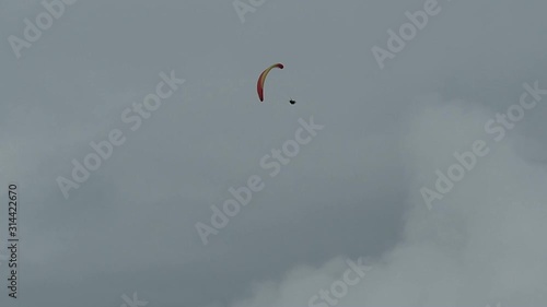 Men paragliding in clouds background and making spinning stunts