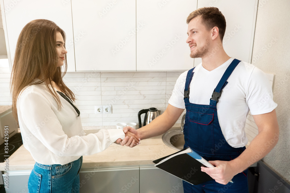 young man plumber and brunette woman client shaking hands after successful installation of water tap iprofessional repair service