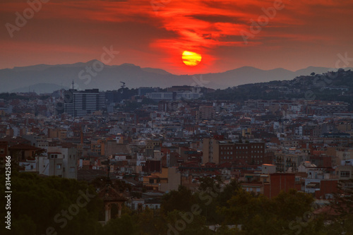 view of the city of Barcelona, capital of province of Catalonia Spain at sunset in summer in front of mountains with red salt and residential buildings in shade