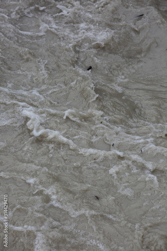 Brudna, zmącona woda po ulwie płynie z dużą prędkością w rzece