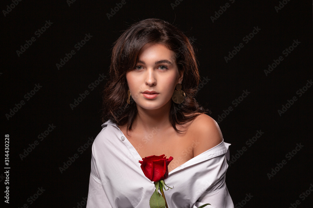 Beautiful woman with bright makeup posing isolated over black background with red rose. Beautiful woman with bright makeup posing isolated over black background with red rose.