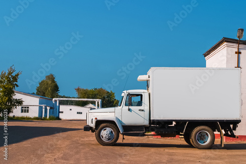 White commercial delivery truck at the farm background