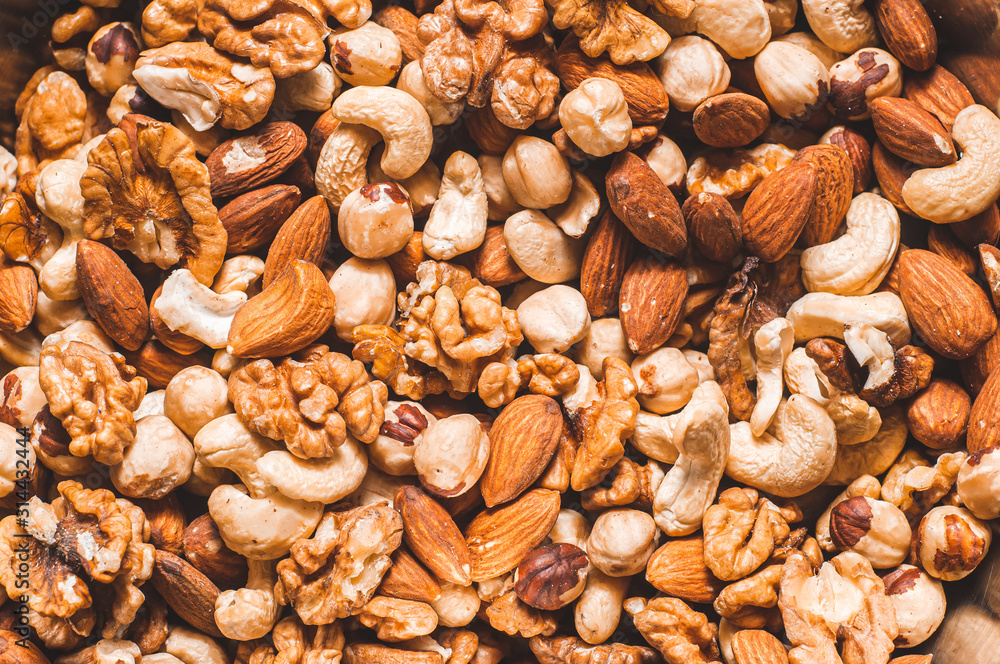 Background of assorted cashews, almonds, greta and hazelnuts mixed closeup. Healthy and wholesome food. Background of assorted cashews, almonds, greta and hazelnuts mixed closeup. Healthy and wholesome food.